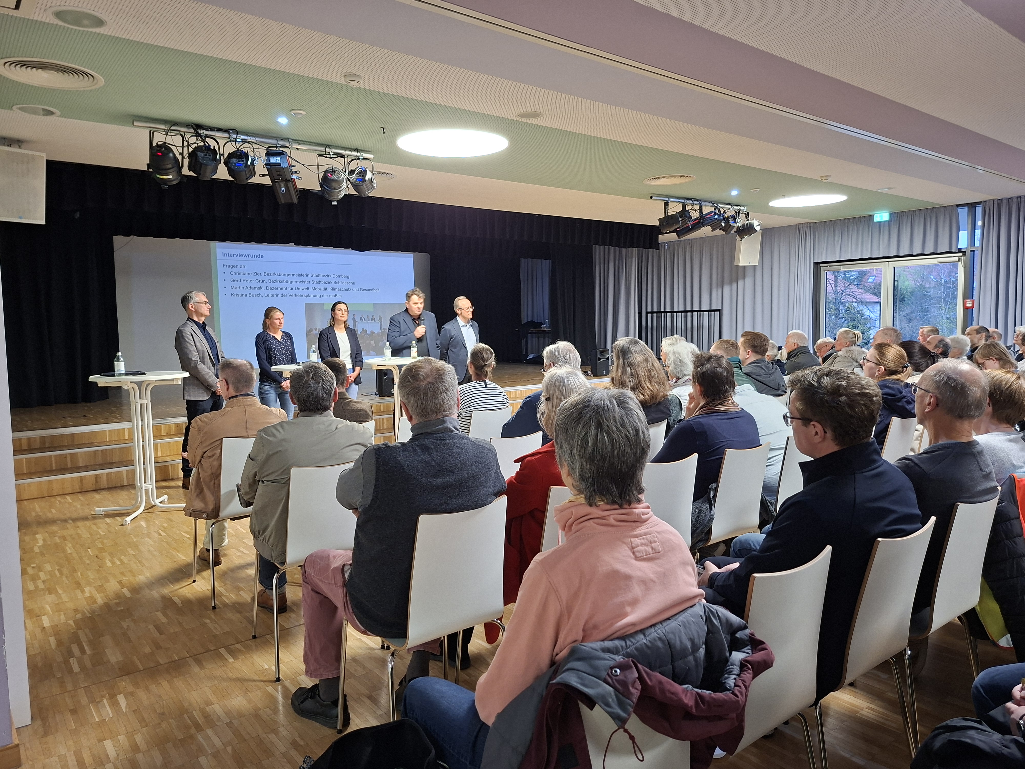Bezirksbürgermeister Gerd-Peter Grün (Schildesche), Kristina Busch (Leiterin Verkehrsplanung moBiel), Bezirksbürgermeisterin Christiane Zier (Dornberg), Martin Adamski (Verkehrsdezernent) und Moderator Stefan Trischler (VWI) beantworteten Fragen aus dem Publikum. Foto: Stadt Bielefeld