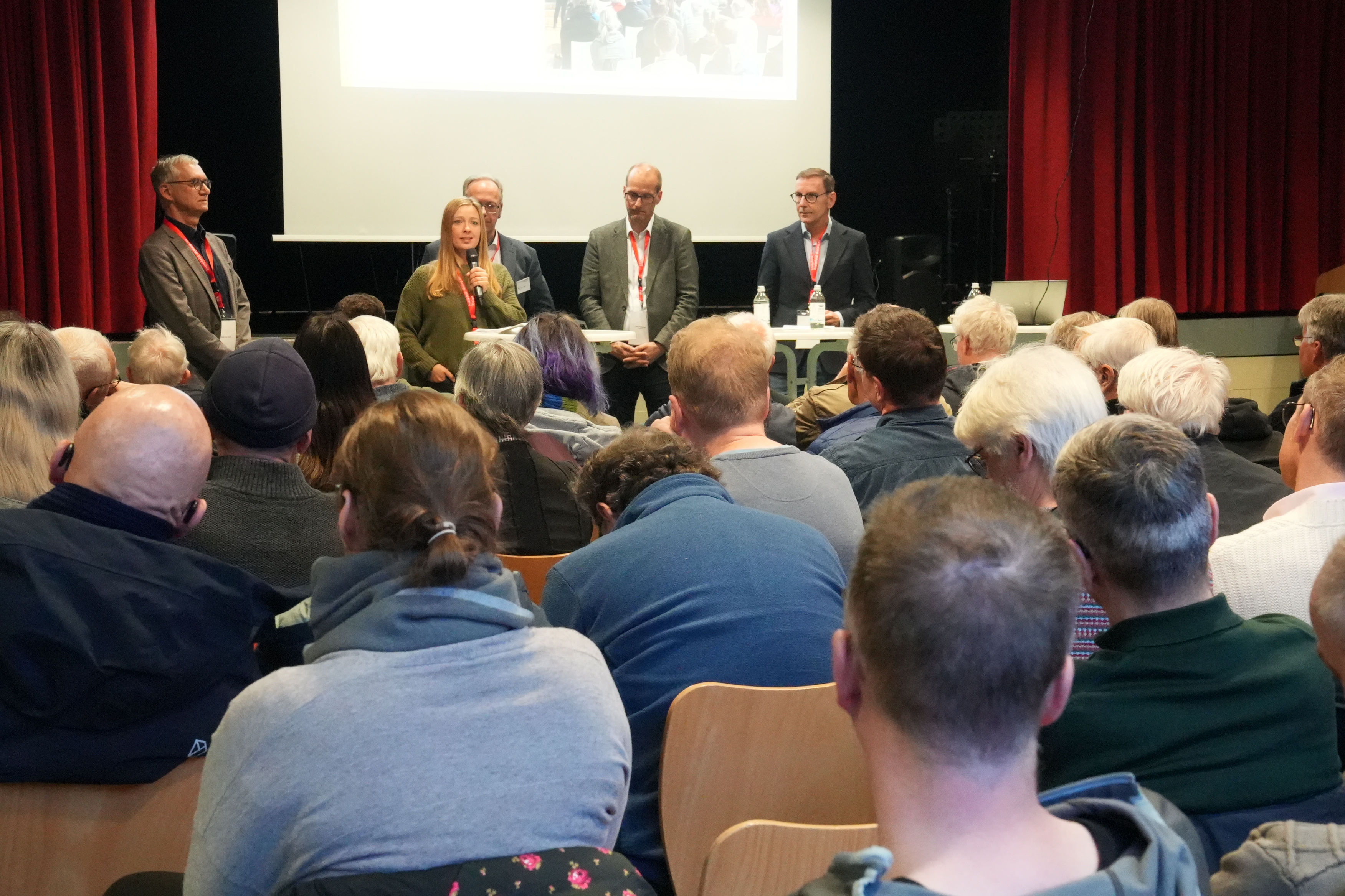 Bezirksbürgermeister Gerd-Peter Grün (Schildesche), Bezirksbürgermeisterin Yvonne Kiel (Jöllenbeck), Arne Petersen (Geschäftsführer moBiel), Olaf Lewald (Leiter Amt für Verkehr) und Moderator Stefan Trischler (VWI) beantworteten Fragen aus dem Publikum. Foto: Stadt Bielefeld