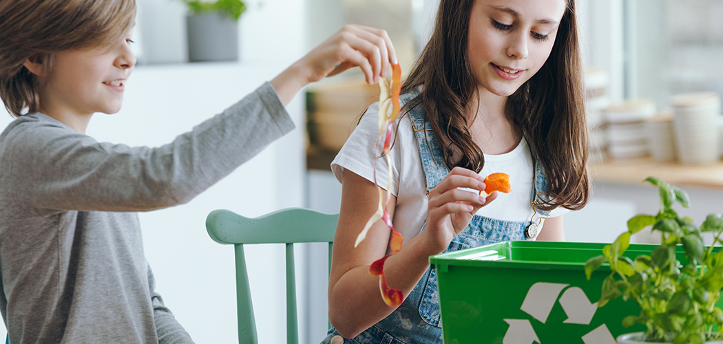 Kinder beim Recycling von Küchenabfällen