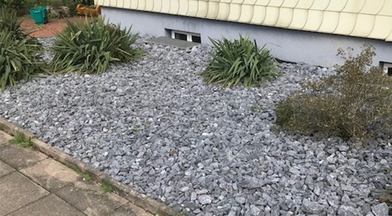 Vorgarten mit viel Schotter und wenig Pflanzen