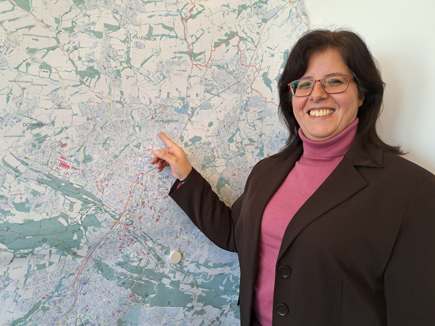 Claudia Koch ist die neue Dezernentin für Wirtschaft und Stadtentwicklung. Foto: Stadt Bielefeld. Die neue Dezernentin Claudia Koch im Profil, sie zeigt auf einen Stadtplan von Bielefeld
