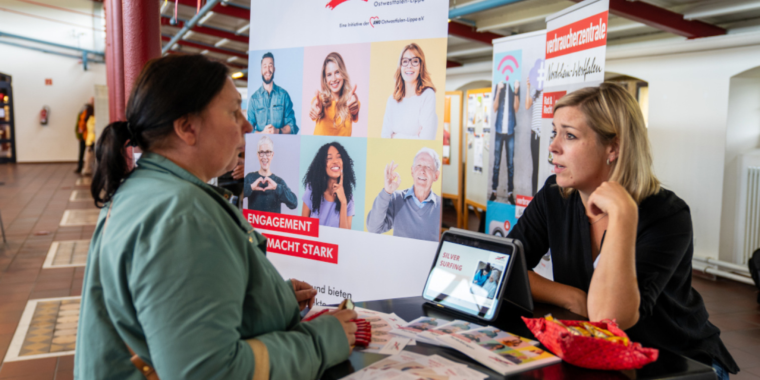 Zwei Frauen unterhalten sich am Stand der Verbraucherzentrale.