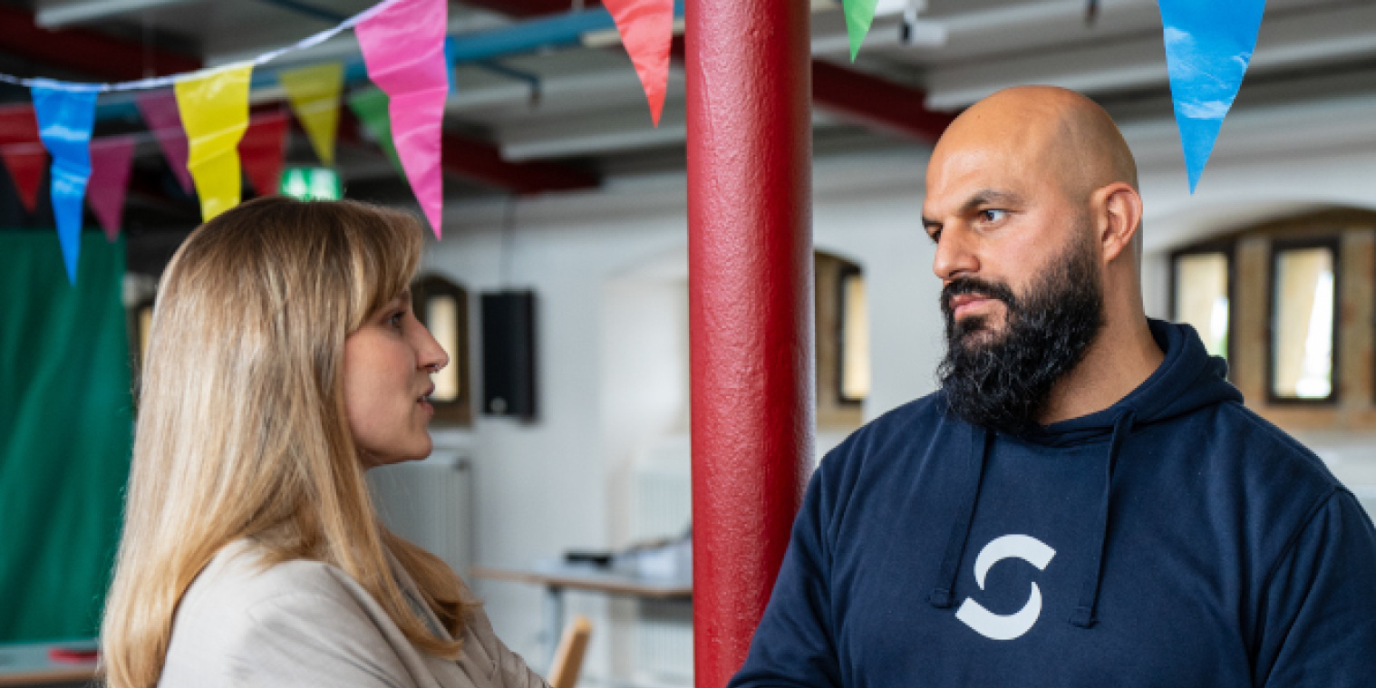 Eine Mitarbeiterin des Digitalisierungsbüros unterhält sich mit einem Angestellten der Stadtwerkde. 