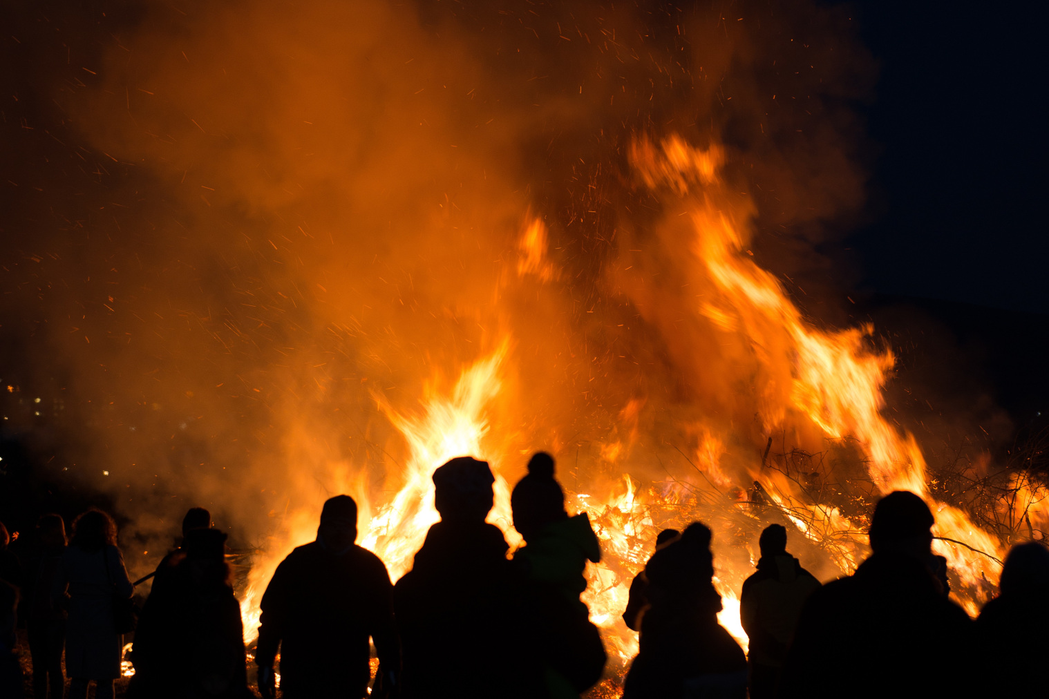 Silhouetten von Personen vor einem Feuer