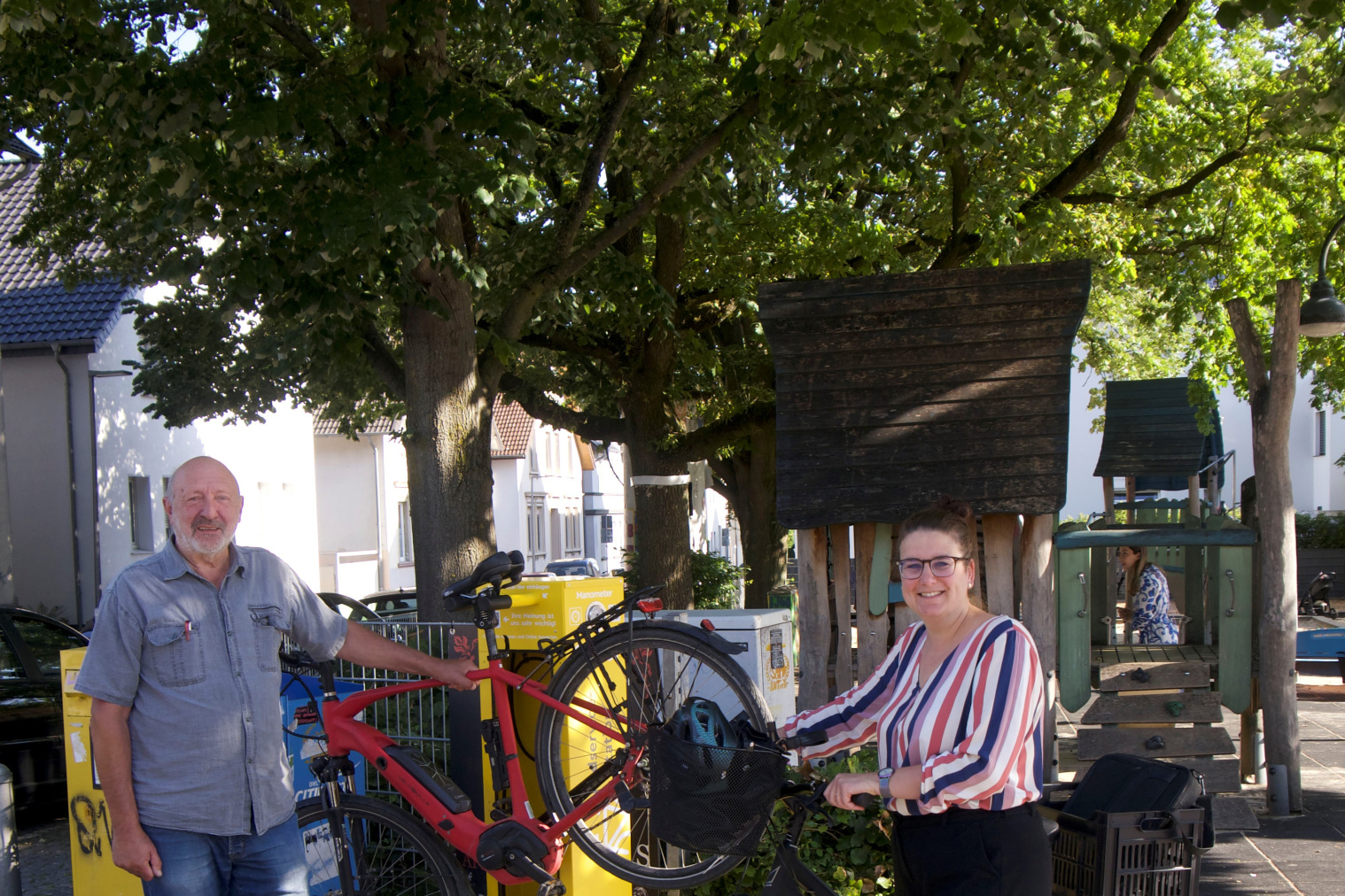 Ein Mann und eine Frau mit ihren Fahrrädern neben der neuen Radstation auf dem Siggi