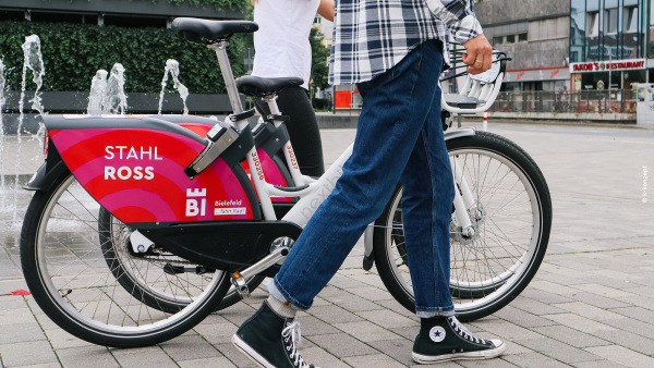 Jugendliche schieben Fahrräder mit der Aufschrift "Bielefeld fährt Rad".