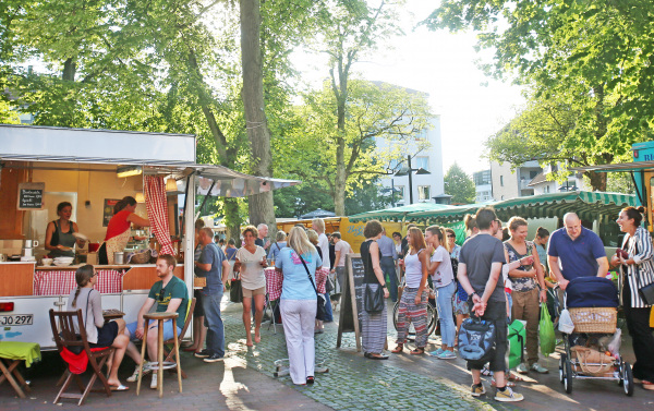 Menschen beim Wochenmarkt auf dem Siegfriedplatz.