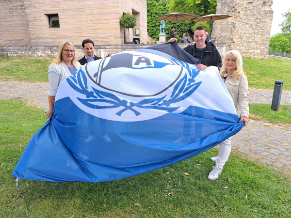 Anlässlich des Aufstiegs vom DSC Arminia Bielefeld in die 2. Fußballbundesliga und dem historischen Einzug in DFB-Pokalfinale wird auf der Sparrenburg die Arminia-Flagge gehisst. Von links: Deborah Becker, Timur Rieger, Fabian Froböse und Petra Löbbert; Foto: Stadt Bielefeld