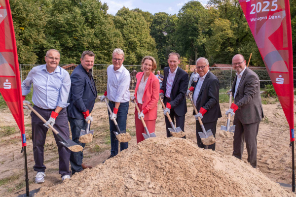 Mit dem ersten Spatenstich von (v.l.) Thomas Finke (Umweltbetrieb der Stadt Bielefeld), Umweltdezernent Martin Adamski, Architekt Kai Brüchner-Hüttemann, Jennifer Erdmann (Vorstand Sparkasse Bielefeld), Dr. Jörn Stöppel (Sparkasse), Oberbürgermeister Pit Clausen und Stefan Dwilies (Sparkasse) hat der Bau des neuen Begegnungshauses im Tierpark Olderdissen offiziell begonnen. Foto: UWB