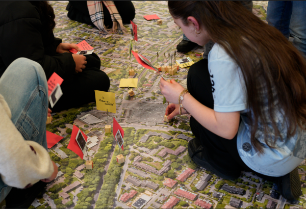 Die Schulkinder stellen Fotos mit Hinweisen auf den riesigen Stadtteil-Teppich. Foto: mobildenker