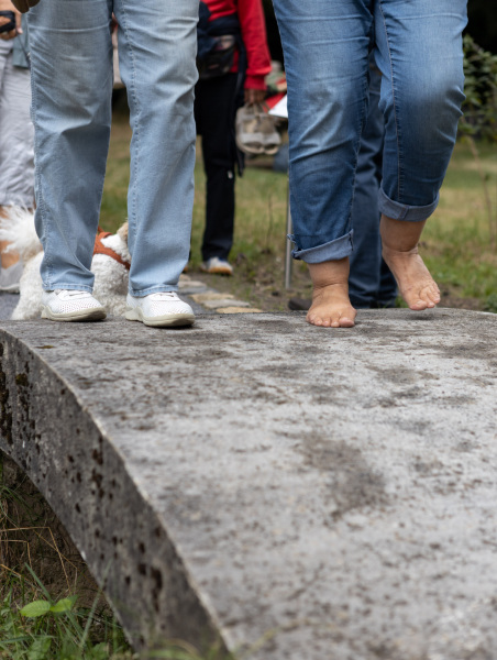 zwei Paar Füße sind zu sehen, einmal mit und einmal ohne Schuhe