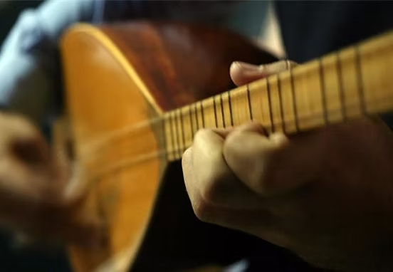Ein Mensch spielt Saz-Gitarre