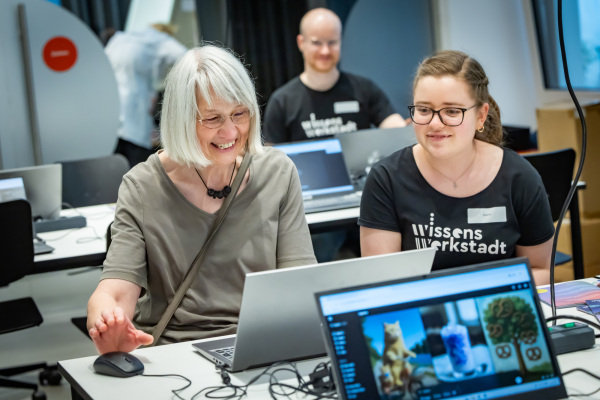 Zwei Personen am Tisch mit Laptops