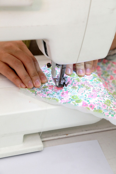 Hand näht Stoff an Nähmaschine