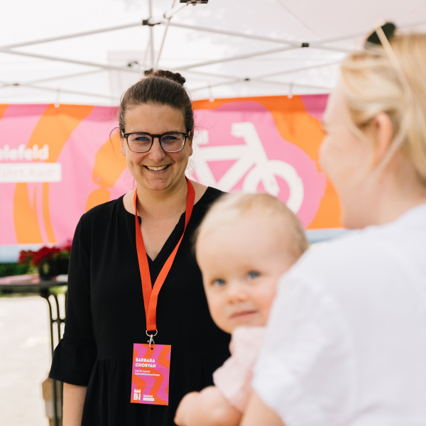 Zwei Frauen und ein Baby auf dem Arm bei einer Veranstaltung von "Bielefeld fährt Rad"