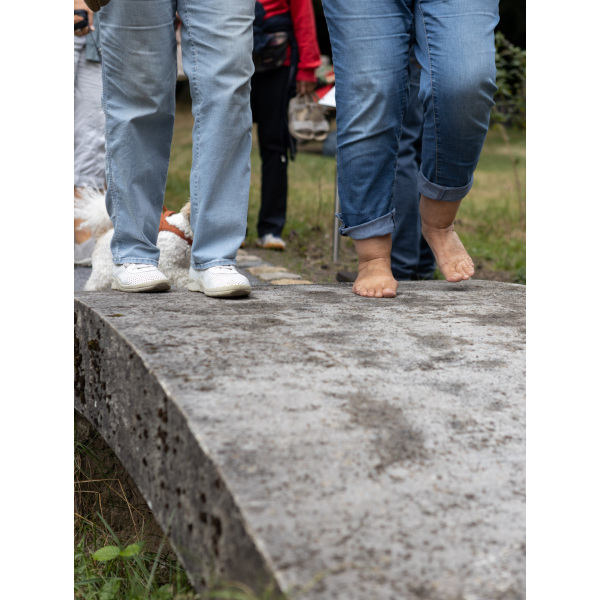 zwei Paar Füße sind zu sehen, einmal mit und einmal ohne Schuhe