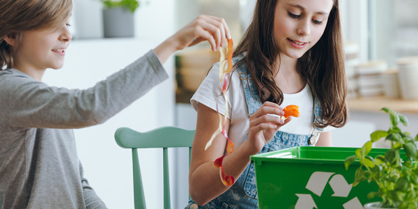 Kinder beim Recycling von Küchenabfällen