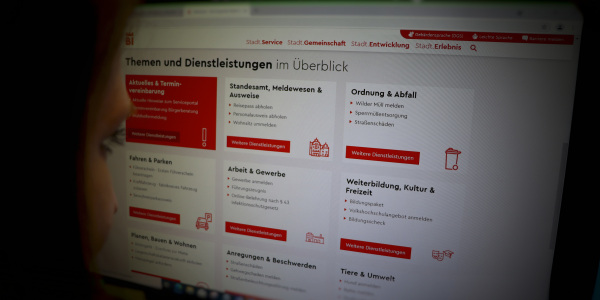 Eine Person schaut auf einen Bildschirm mit dem Serviceportal der Stadt Bielefeld