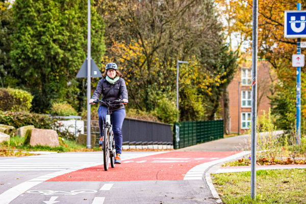 Eine Frau fährt mit ihrem Fahrrad auf einem Radweg