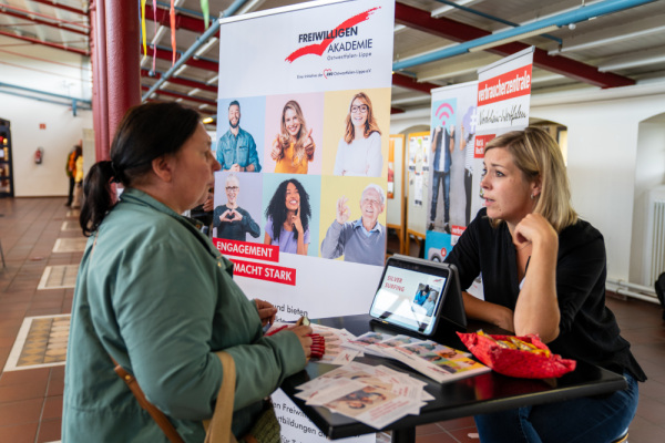 Zwei Frauen unterhalten sich am Stand der Verbraucherzentrale.