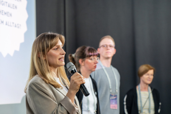 Organisator*innen des Markts der digitalen Möglichkeiten halten eine Eröffnungsrede. 