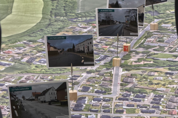 Die Fotos zeigen die Maßnahmen-Vorschläge zur Fahrradstraße und sind auf dem großen Stadtteil-Plan angeordnet. Foto: Stadt Bielefeld