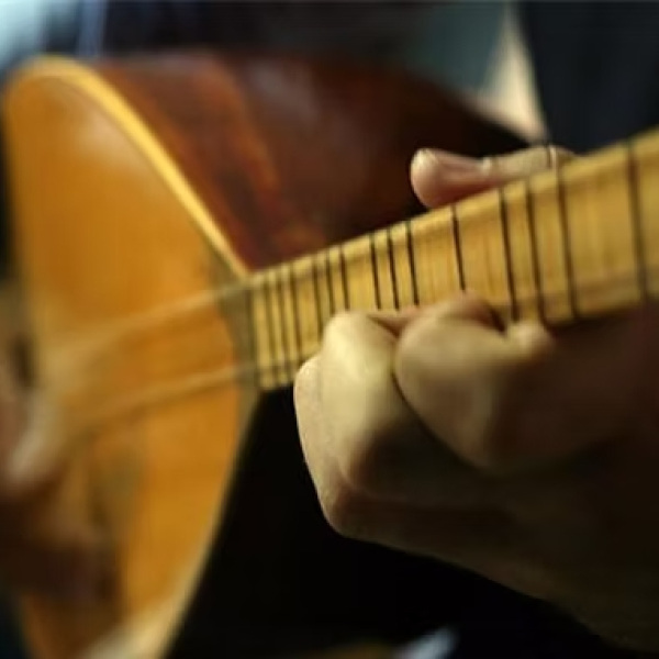Ein Mensch spielt Saz-Gitarre
