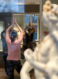 Zwei Frauen machen zwischen Ausstellungsobjekten Yoga. Foto: Nadine Butigan