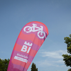 Beachflag mit der Aufschrift "Bielefeld fährt Rad" vor blauem Himmel