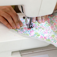 Hand näht Stoff an Nähmaschine